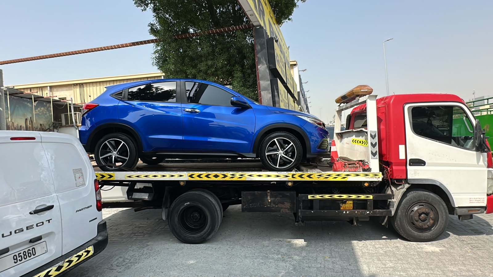 Car recovery service Dubai flatbed loading a vehicle